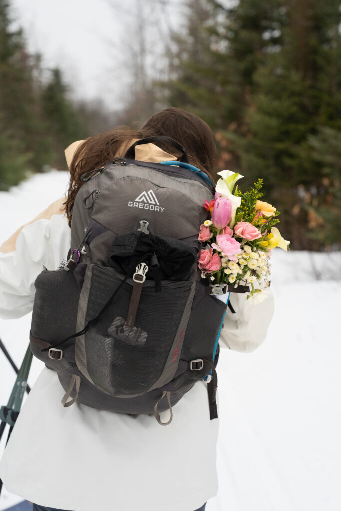 flowers in backpack during winter cross country ski elopement 