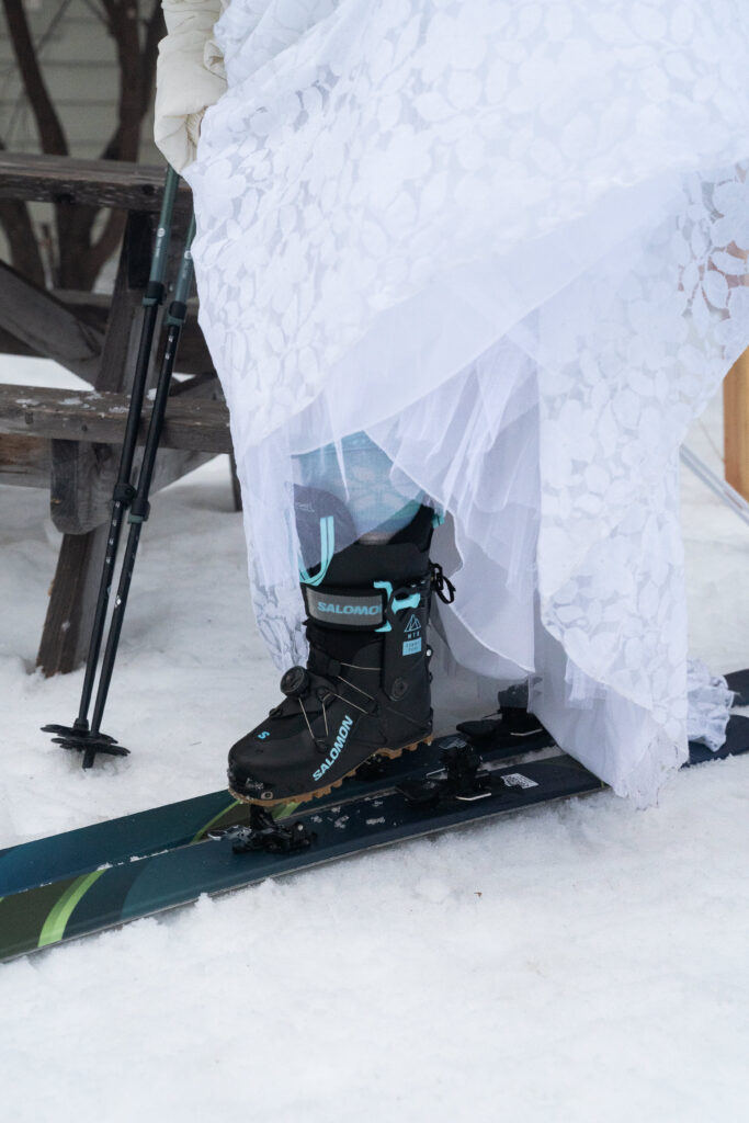 Winter Wedding dress with ski boots and skis for ski adventure with maine Huts and trails 