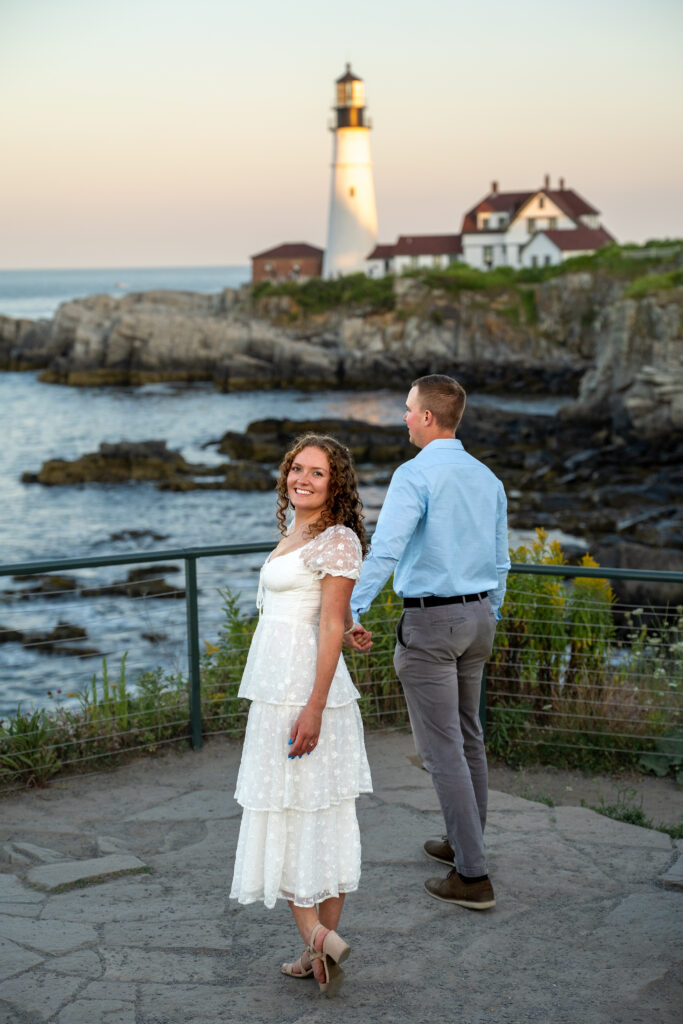 Newlyweds holding hands during a small elopement ceremony at Portland Head Light surrounded by coastal Maine scenery